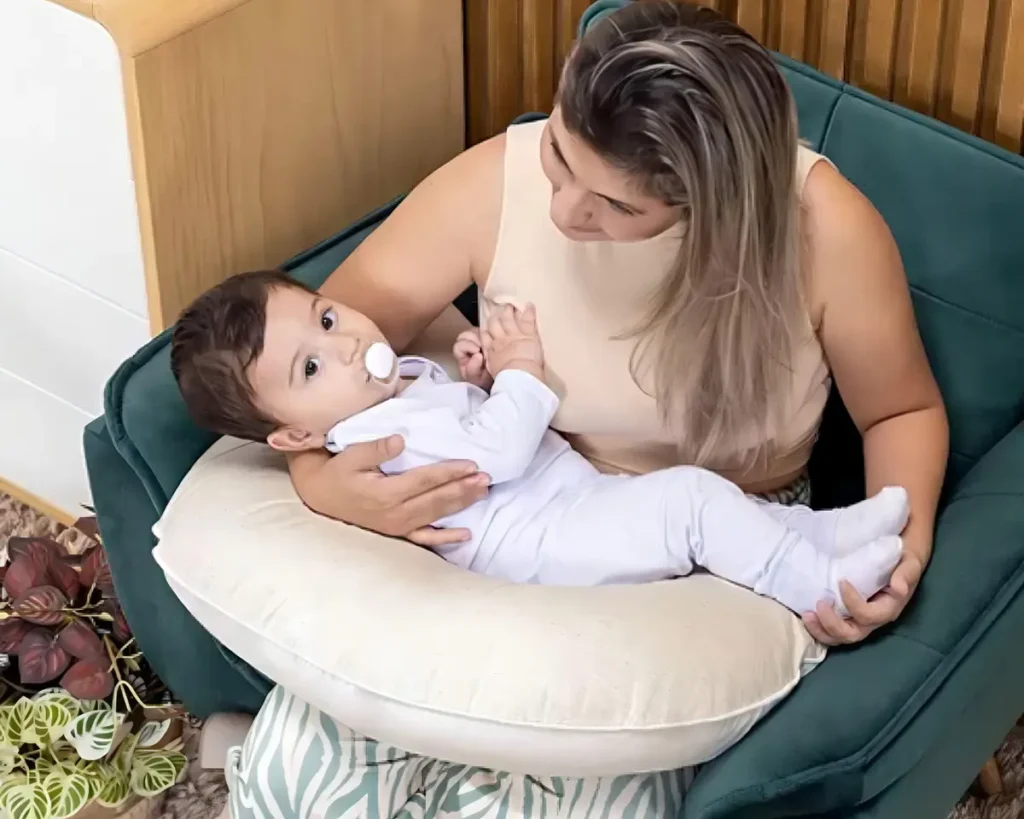 Almofada de amamentação ergonômica em formato de 'U' revestida em tecido de linho bege macio.